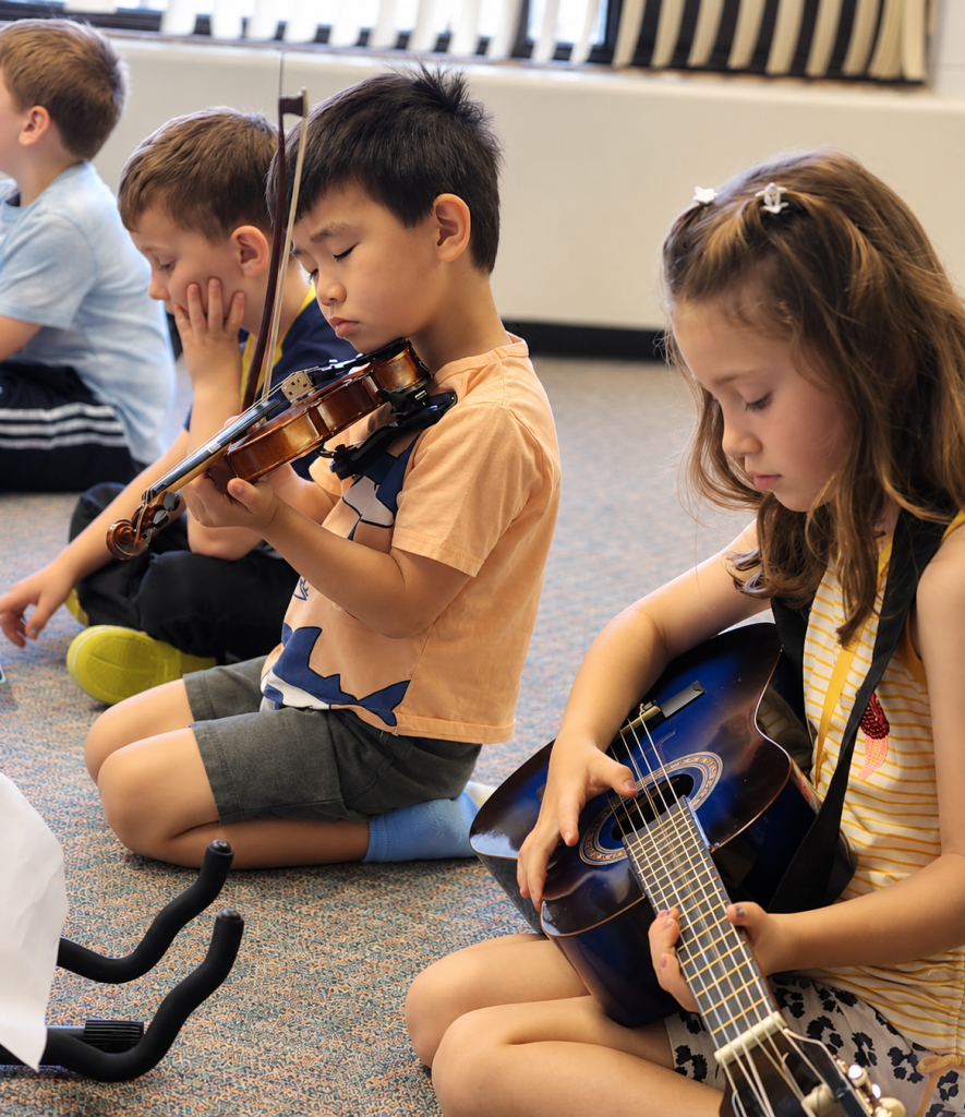 Little children playing instruments in a classroom